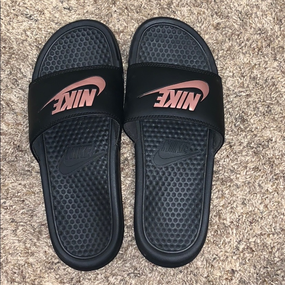 Woman’s black NIKE slides with rose gold “NIKE”